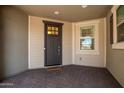 Front entry with dark door, window, and tile flooring at 13713 W Harvest Ave, Litchfield Park, AZ 85340