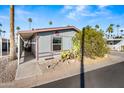 Front view of a single-wide manufactured home with mature landscaping at 150 S Windsor -- # F87, Mesa, AZ 85204