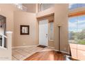 Two-story entryway with tile flooring and a wood staircase at 18877 N 59Th Dr, Glendale, AZ 85308