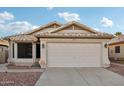 Tan house with tile roof, two-car garage, and landscaped yard at 20947 N 107Th Dr, Peoria, AZ 85373