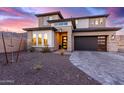 Two-story home with modern design, stone accents, and a three-car garage at 21632 W Hillcrest Blvd, Buckeye, AZ 85396