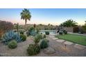 Landscaped backyard with putting green, desert plants, and a relaxing patio area at 23861 N 74Th Pl, Scottsdale, AZ 85255