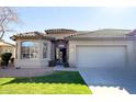 Single-story home with tile roof, two-car garage, and well-manicured lawn at 23901 S Vacation Way, Sun Lakes, AZ 85248