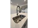 Modern kitchen sink and faucet with white quartz countertop at 25312 W Bowker St, Buckeye, AZ 85326