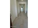 Long bright hallway with tile floor and recessed lighting leading to the home's interior at 25318 W Bowker St, Buckeye, AZ 85326