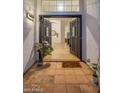 Inviting entryway with double doors, terracotta tile flooring, and a welcoming mat at 3077 W Ironwood Cir, Chandler, AZ 85226