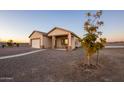 Tan one-story house with attached garage and covered porch at 34214 W Sahuaro St, Tonopah, AZ 85354