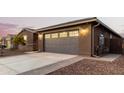 View of the garage and exterior of the house at dusk at 35350 W Marin Ave, Maricopa, AZ 85138