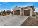 Two-car garage with a long driveway and desert landscaping at 3677 N Hudson Dr, Florence, AZ 85132