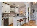 Modern bar with granite countertop, wine cooler, and custom cabinetry at 3838 E Devonshire Ave, Phoenix, AZ 85018