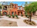 Two-story home with Spanish-style architecture, landscaping, and a walkway at 3935 E Rough Rider Rd # 1235, Phoenix, AZ 85050