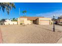 Tan house with a two-car garage and gravel driveway at 5448 W Shaw Butte Dr, Glendale, AZ 85304