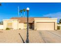 Tan house with a two-car garage and gravel driveway at 5448 W Shaw Butte Dr, Glendale, AZ 85304