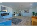 Open-concept living room flows into kitchen with modern fireplace, wood floors, and neutral paint at 5725 W Osborn Rd, Phoenix, AZ 85031