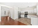 Bright kitchen features white cabinets, stainless steel appliances, and hardwood flooring near the entrance at 60 W Beechnut Pl, Chandler, AZ 85248