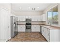 Well-lit kitchen featuring stainless steel appliances and white cabinets provides ample space at 60 W Beechnut Pl, Chandler, AZ 85248