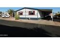 Mobile home with desert landscaping and golf cart at 8600 E Broadway Rd # 43, Mesa, AZ 85208