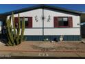 Cute single-wide mobile home with red shutters and desert landscaping at 8600 E Broadway Rd # 43, Mesa, AZ 85208