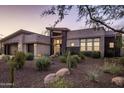 Luxury home with desert landscaping, stone accents, and a three-car garage at 17220 E Lonesome Canyon Ct, Rio Verde, AZ 85263