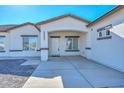 Modern home's front entrance with a covered porch and white door at 20823 W Rainbow Trl, Buckeye, AZ 85326