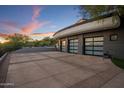 Three-car garage with modern glass panel doors and a large concrete pad at 3282 E Palo Verde Dr, Paradise Valley, AZ 85253