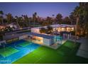 Night view of house, pool, and sports court at 5817 E Leith Ln, Scottsdale, AZ 85254
