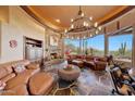 Comfortable living room with a stone fireplace and panoramic views at 6520 E El Sendero Rd, Carefree, AZ 85377