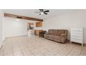 Living room with tile floors, brown couch, and view of kitchen at 8241 N Central Ave # 11, Phoenix, AZ 85020