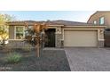 Single-story home with brick facade, two-car garage, and landscaped front yard at 11555 W Marguerite Ave, Avondale, AZ 85323