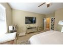 Bedroom with large TV, dresser and access to upper level at 13612 W Cypress St, Goodyear, AZ 85395