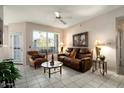 Relaxing living room featuring a brown leather couch and tiled floors at 14950 W Mountain View Blvd # 3209, Surprise, AZ 85374