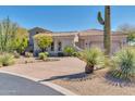 Single-story home with desert landscaping and a three-car garage at 37181 N 103Rd St, Scottsdale, AZ 85262