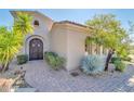 Front entrance with wooden doors and desert landscaping at 37181 N 103Rd St, Scottsdale, AZ 85262