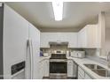 Kitchen with white cabinets, stainless steel appliances, and a double sink at 4608 W Maryland Ave # 127, Glendale, AZ 85301