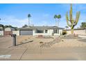 Ranch-style home with gray garage door and well-maintained desert landscaping at 4942 E Wethersfield Rd, Scottsdale, AZ 85254