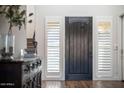 Inviting entryway with a dark wood door flanked by shuttered windows and stylish decor at 5528 E Windstone Trl, Cave Creek, AZ 85331
