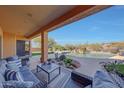 Covered patio with comfortable seating, overlooking the pool and desert landscape at 9322 E Hidden Green Dr, Scottsdale, AZ 85262