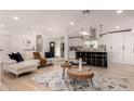 Open living room features a sectional sofa, stylish coffee tables, and flows into the updated kitchen at 126 E Northern Ave, Phoenix, AZ 85020