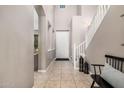 Bright entryway with tiled floors, staircase, and a bench with pillows at 20562 E Raven Dr, Queen Creek, AZ 85142