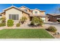 Beautiful two-story home featuring neutral desert color palette, manicured front yard, and desert landscaping at 20562 E Raven Dr, Queen Creek, AZ 85142