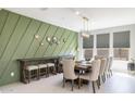 Elegant dining room with wood table and statement green wall at 27165 N 71St Ln, Peoria, AZ 85383