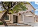 Two-story house with tan exterior, decorative door, and garage at 6537 W Riva Rd, Phoenix, AZ 85043