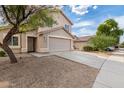 Two-story house with tan exterior, landscaping, and driveway at 6537 W Riva Rd, Phoenix, AZ 85043