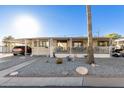 Mobile home exterior with covered porch, palm tree, and gravel landscaping at 9333 E University Dr # 147, Mesa, AZ 85207