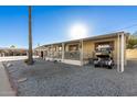 Mobile home exterior with covered porch and golf cart, viewed from the street at 9333 E University Dr # 147, Mesa, AZ 85207