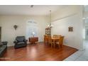 Dining area with hardwood floors and wood table, adjacent to living room at 11503 W Cyprus Dr, Avondale, AZ 85392