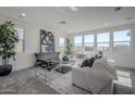 Sun-filled living room features a large window, neutral paint and carpet, and modern decor at 17219 W Vacaville St, Surprise, AZ 85388