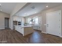 Spacious kitchen with island, white cabinets, and herringbone floors at 17380 W Carlisle Dr, Surprise, AZ 85388