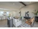 Bright and open living room with stylish furnishings, a vaulted ceiling, and seamless flow into the kitchen at 17380 W Carlisle Dr, Surprise, AZ 85388