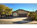 Tan house with brown garage door and landscaping at 1933 S Peppertree Dr, Gilbert, AZ 85295